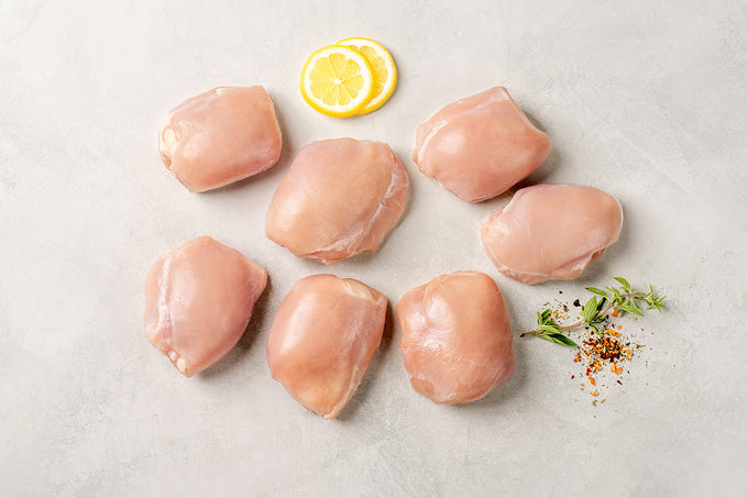 Raw boneless chicken breasts with a slice of lemon